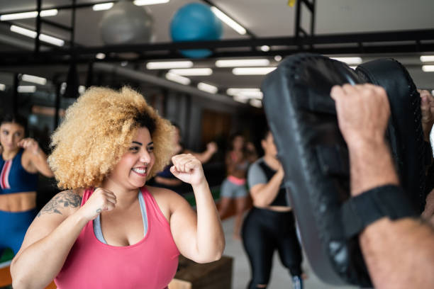 フィットネスインストラクターとボクシングトレーニング中の女性 - fighting stance 写真 ストックフォトと画像