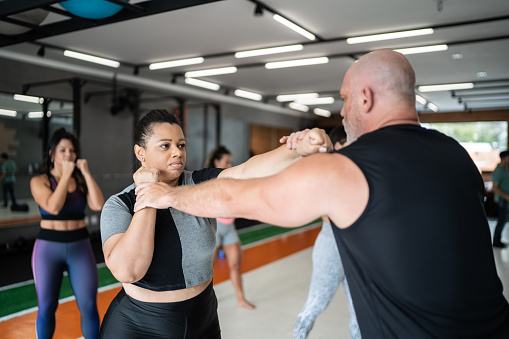 Intructor defending himself during boxing training at the gym