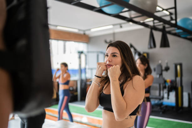 istock Woman on boxing training with fitness instructor 1323056573