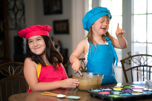 Two friends following a cupcake recipe online