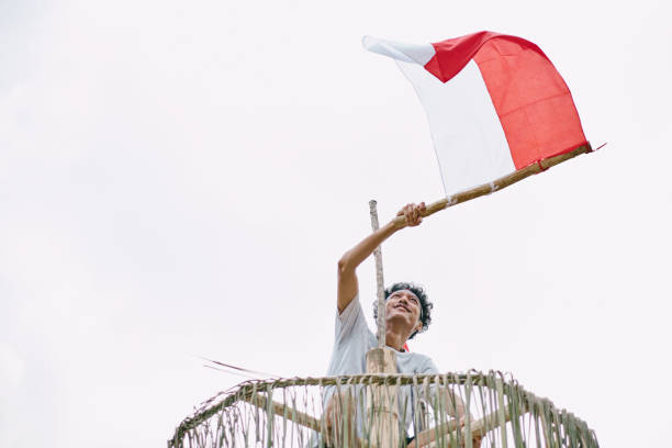 Elementary school children salute the Indonesian flag to commemorate Indonesia's independence day during the COVID 19 pandemic