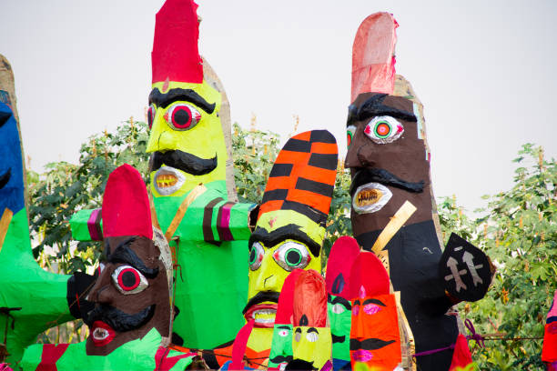 roadside streetside shot of huge paper mache effigies puppets of demon ravana being built in colorful paper to be burnt on the eve of dussehra Vijayadashami to be filled with fireworks for the hindu festival. Sold by poor artisans who make these in bulk to sell toma al borde de la calle al borde de la carretera de enormes efigies de papel maché títeres de demonio ravana que se construyen en papel de colores para ser quemado en la víspera de dussehra vijayadashami para ser llenado de fuegos artificiales para el