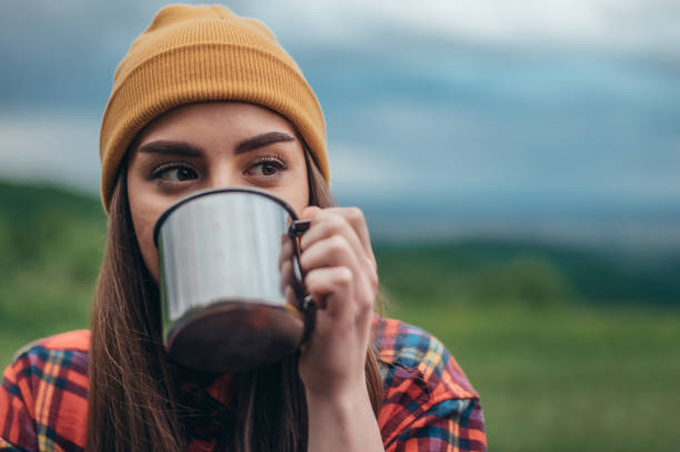 istock Woman camper spending a day in nature while drinking coffee from a metal cup 1323063268