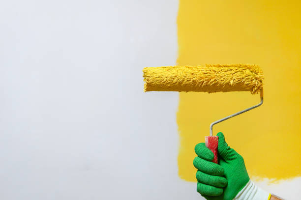 istock Male hand painting wall with paint roller 1323064407