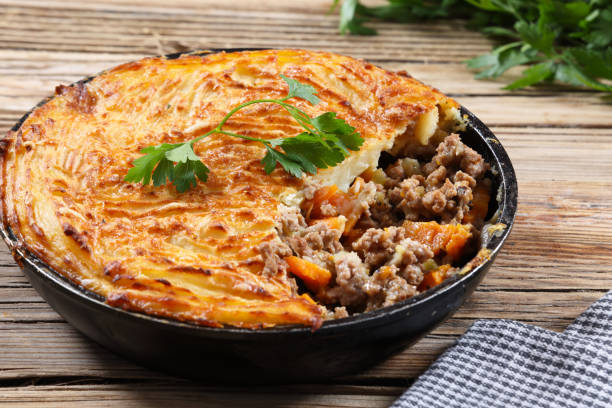 Cottage Pie or Shepherds Pie Shepherd's Pie with minced Lamb, or Cottage Pie with minced Beef, or hachis Parmentier, is a ground meat pie with a crust or topping of mashed potato. The dish has many variants, but the defining ingredients are ground red meat cooked in a gravy or sauce with onions, and a topping of mashed potato and cheese. High resolution 45Mp pictures using Canon EOS R5 and associate lenses. meat pie stock pictures, royalty-free photos & images