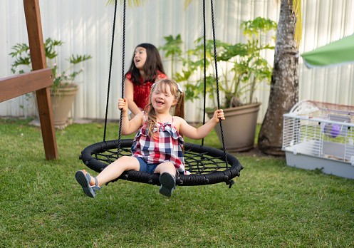 Two empty wooden swing with sunlight in playground.