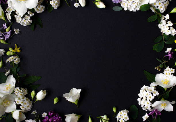 istock Floral frame made of different spring flowers on black background. Flowers flat lay. Space for text 1323070921
