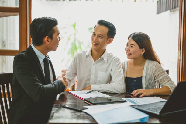 istock Real Estate Agent Shaking Hands With His Clients 1323072113