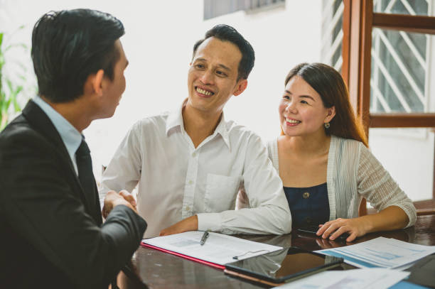 istock Real Estate Agent Shaking Hands With His Clients 1323072150