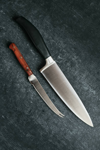 istock Two household kitchen knives on dark background, top view 1323072296
