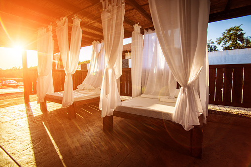 Baldachin bed stock photo. Sunny canopy with a bed in a resort. No people photography.