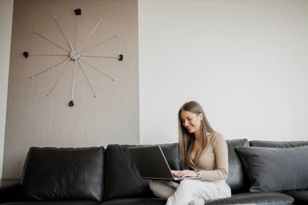 istock Young woman using her laptop, working and having video call at home office 1323075881