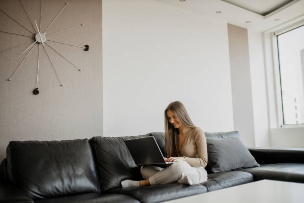 istock Young woman using her laptop, working and having video call at home office 1323075966