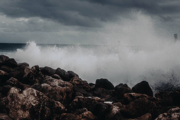istock Huge white foamy waves crashing against the stone shore 1323076731