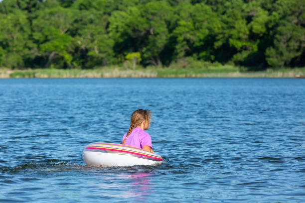 девушка во внутреннем трубе плавать кольцо на озере летом - inner tube swimming lake water стоковые фото и изображения