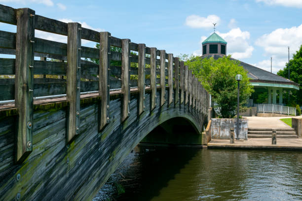 istock A bridge over water in a park leading to a large gazebo 1323077800
