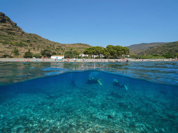 istock Spain beach coastline and scuba divers underwater 1323078652