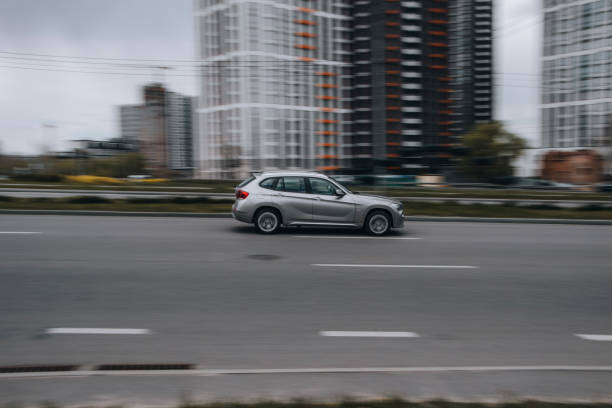 voiture bmw x1 argentée se déplaçant dans la rue. - bell photos et images de collection