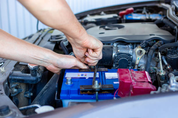 riparazione e installazione della batteria sotto il cofano di un'auto - battery replacement foto e immagini stock