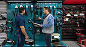 Customer shopping for tools at a hardwarestore and talking to a salesman