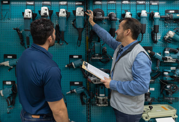 istock Salesman at a hardware store showing tools to a customer 1323082617