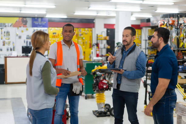 geschäftsinhaber im gespräch mit einer gruppe von mitarbeitern in einem baumarkt - sales clerk store manual worker retail stock-fotos und bilder