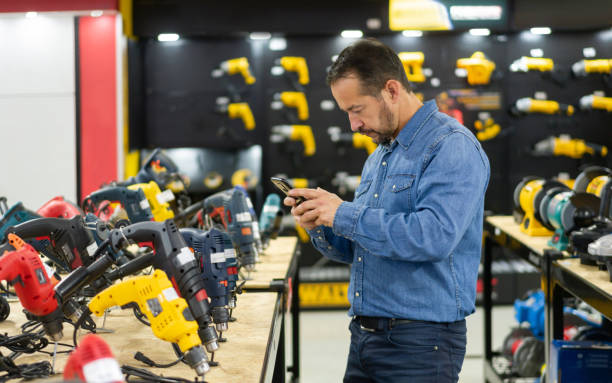 uomo che fa shopping in un negozio di ferramenta e scatta una foto degli strumenti - hardware store store work tool customer foto e immagini stock