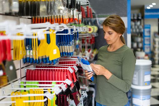 Latin American woman shopping at a hardware store buying tools for a DIY project