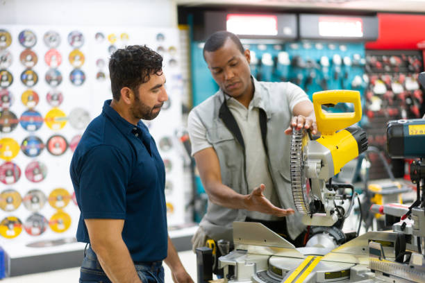 istock Salesman talking to a client while selling him tools at a hardware store 1323082770