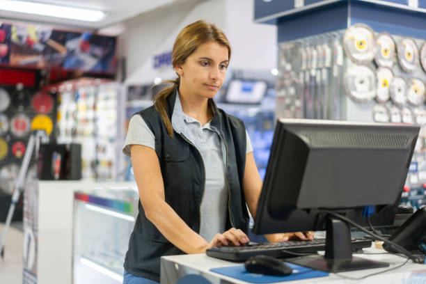 Woman working at the teller at a hardware store Happy Latin American woman working at the teller at a hardware store -small business concepts hardware store photos stock pictures, royalty-free photos & images