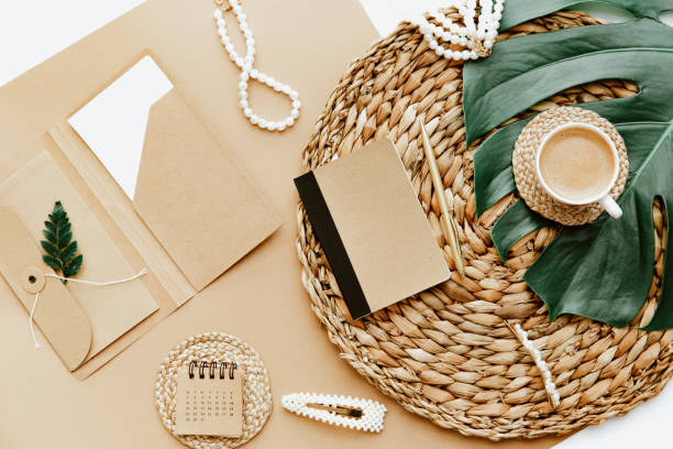 istock Women workplace. Flat lay blank paper notebook, female accessories  on brown background. Freelancer workspace, todo list, home office desk, planning concept 1323083036
