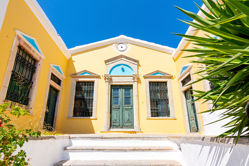 Symi, Greece - September 2019: Old yellow house in Symi town