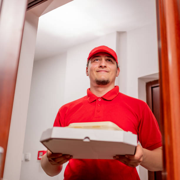 istock handsome man in red shirt delivering food 1323087382