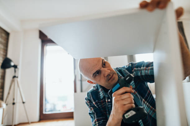 istock Mature man assembling furniture at home, using electric drill 1323088438