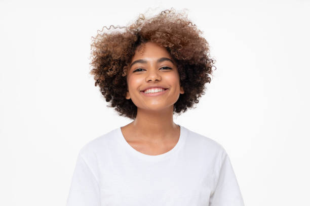 porträt von lachenden afrikanischen mädchen in weißen t-shirt blick auf die kamera, isoliert auf grauem hintergrund - i t stock-fotos und bilder