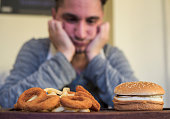 mann-lehnt-einen-burger-mit-daumen-nach-