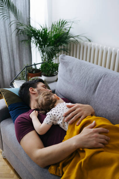 istock Handsome Father with Little Daughter Sleeping on Sofa 1323095400