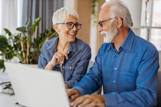 старшая пара в домашнем офисе - computer old men laptop стоковые фото и изображения