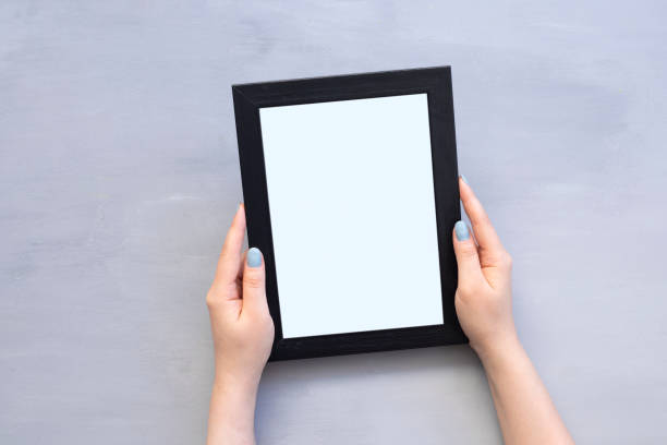 istock Woman’s hands holding empty photo frame on white background. Close up 1323100753
