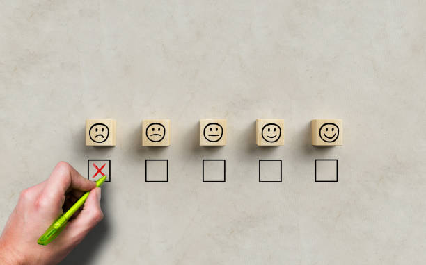 istock hand selecting a sad emoticon symbolizing a bad review 1323101005
