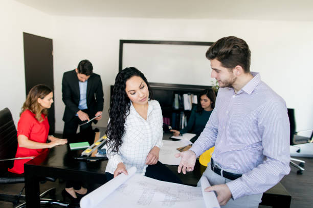 istock Male and female architects looking at architectural plan in conference room 1323102535