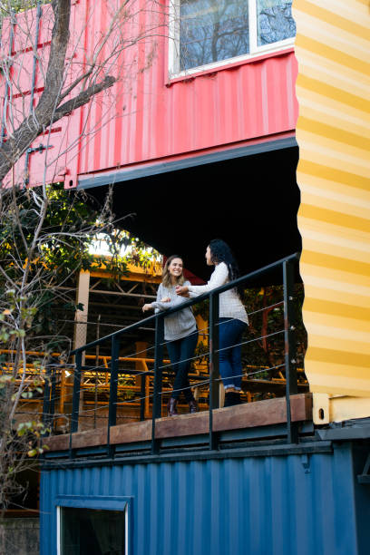 istock Two young women standing on balcony in colorful building 1323103029