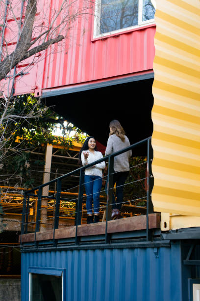 istock Two young women standing on balcony and talking 1323103098