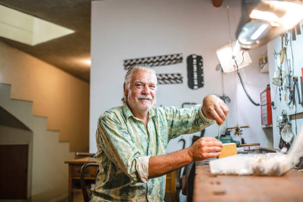 istock Mature Man Making Repairs at Workbench in Home Basement 1323107335