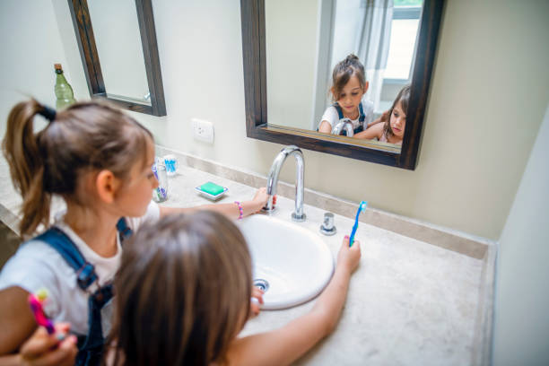 istock Hispanic Sisters Brushing Teeth in Family Bathroom 1323107341