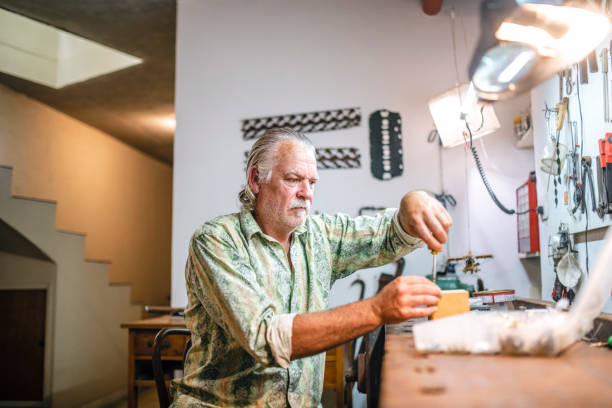 istock Mature Man Using Screwdriver for Repairs in Home Workshop 1323107374