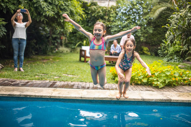 istock Sisters Playing in Backyard Swimming Pool 1323107385