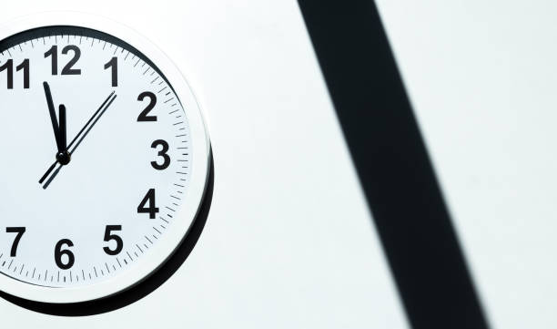istock Close up to a wall clock, with five minutes to twelve o'clock 1323112219