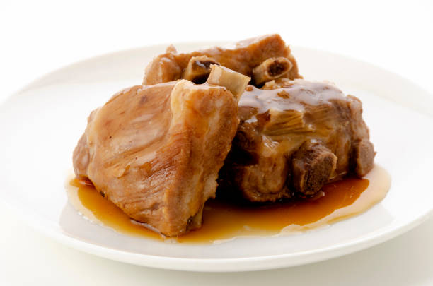 Stewed pork ribs on white plate on white background.