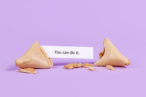 Fortune cookie with motivational text saying 'You can do it' on purple background